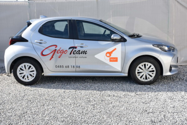 Vue latérale d'une voiture Toyota Yaris grise avec un logo GégoTeam