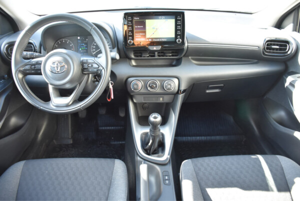 L'intérieur d'une voiture Toyota Yaris avec un volant, un écran tactile et des commandes ergonomiques