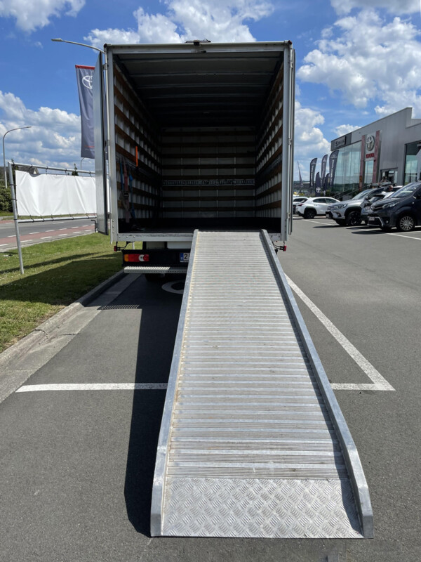 Vue de l'arrière d'un grand camion de déménagement avec une rampe métallique